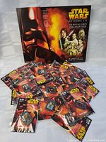 Photo showing all 20 individually sealed character pins spread out with Episode III Star Wars display binder behind them.