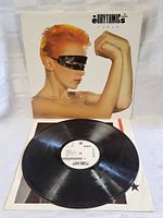 Photo showing vinyl LP record with Eurythmics Touch album cover featuring a person with orange hair and blindfolded with a black strip.