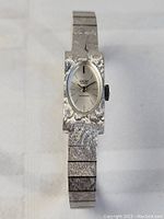 Front view of the vintage Gruen Geneve ladies watch laid out flat on a white surface, showing the textured metal band and case.