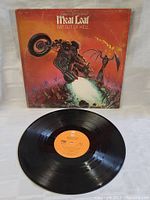 Vinyl record LP on white fabric background showing orange label and clean grooves.