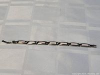 Full view of the sterling silver bracelet showing all linked rectangular sections with light pink insets.