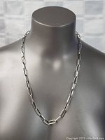Sterling silver chain necklace displayed on a grey mannequin bust, showing the front view of large rectangular links and link pattern.