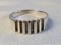 Close-up front angle showing the ring's six vertical rectangular bars and polished sterling silver finish.