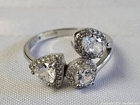 Close-up image of the sterling silver ring showing three large clear stones in trio settings on a silver band stamped 'Sterling' and size 8.