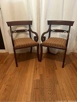 Front view of the two hardwood chairs showing their design and upholstered seats.