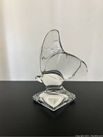 Solid clear crystal butterfly figurine viewed from front and side angles on neutral background, clearly showing the shape and craftsmanship.