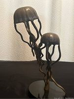 Front view of brass dancing jellyfish sculpture with two jellyfish figures and marble base