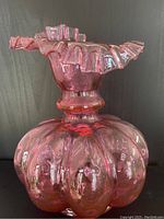 Front and top view of pink Fenton glass vase showing ruffled crimped rim and bulbous segmented body