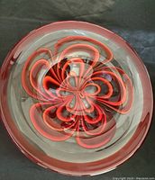 Top view of large glass bowl showing intricate red and black swirl pattern and red rim