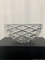 Side view of clear glass bowl showing diamond cut pattern and shape.