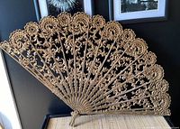 Full view of the large carved decorative fan showing floral details and shape