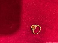 Ring on a red velvet background showing the sapphire and diamond setting.