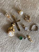 Jewelry pieces arranged on fabric background showing all items in lot including pendants and earrings.