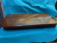 Top view of antique wooden folding shelf showing wood grain and smooth polished finish.