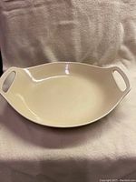 Top view of the oval cream enameled bowl showing smooth enamel surface and dual handles