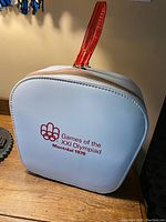 Front side view of the bag showing the 1976 Montreal Olympics logo printed in red on white material with red handle.