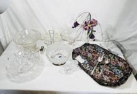Wide shot of the entire glassware set showing American Brilliant Period cut glass bowl, other clear glass bowls and vessels, silver-plated utensils, salt and pepper shakers, and floral tapestry tray
