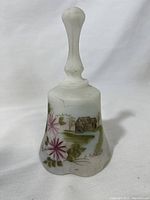 Front view of white frosted glass hand painted bell with floral and rural house scene, artist signature visible