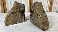 Two large stone bookends placed opposite each other showing natural color variation, rough edges, and overall shape.