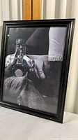 Front view of the framed black and white photographic print of Louis Armstrong playing trumpet, showing the full frame and a portion of the print.