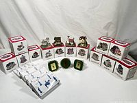 Lot arranged with 19 Liberty Falls miniature buildings and boxed pewter figurines against white backdrop