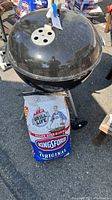 Overall view of Weber charcoal grill with Kingsford charcoal bag placed in front.