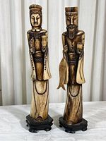 Pair of carved Chinese man and woman figurines mounted on wooden bases, showing full front view.