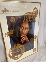 Framed Bob Marley poster with gold lion illustrations and text