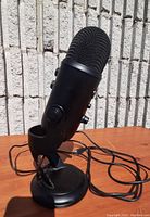 Front-left angle showing microphone mounted on stand with visible cable wrapped at base.