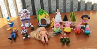 Full spread of all figurines and toys presented on a table outdoors with natural lighting.