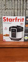 Front side of the Starfrit electric pressure cooker box showing the product image and brand name