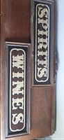 Top view showing both signs labeled 'WINES' and 'SPIRITS' with wood frames and mirrored backgrounds.