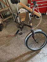 Side view showing entire bike frame, front wheel with fender, saddle, and attached luggage carrier at rear.