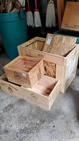 Overview of four wooden wine boxes and a larger crate with a lid made of composite wood panels.