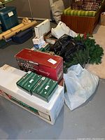 Large lot of Christmas decorations including boxes and bags with tree, lights, nativity, garland, and more
