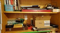 Overview shelf with drawing books, digital calipers, cardboard box, wooden micrometer case