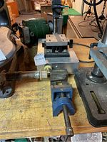 Dremel drill press and Stanley vice positioned on a wooden bench showing the tools in their stored condition