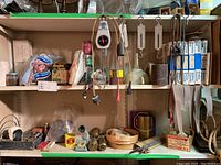 Two shelves displaying multiple rolls of Economy brand sandpaper, assorted files, safety goggles, belts, and hanging tools.