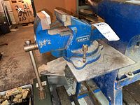 Side view of blue Record No. 2 bench vise mounted to workbench with disassembly label attached.