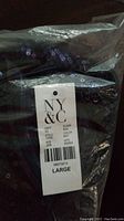 NY&CO tag showing size Large attached to sequin jumpsuit in packaging