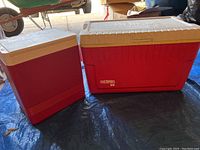 Two red coolers: large Thermos brand and smaller cooler with white lids and red bodies.