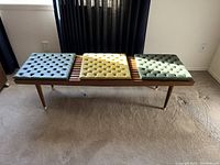 Full front view of wood slat bench with three cushions