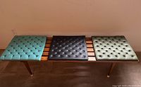 Bench top view with three tufted vinyl cushions in teal, black, and green