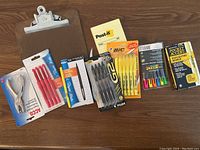 Photo showing clipboard, pens, highlighters, sticky notes, stapler in original packaging.