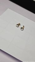 Pair of 925 sterling silver stud earrings with small, natural freshwater pearls.