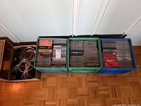 Photo showing three milk crates filled with classical music CDs and a box of coiled speaker wire cables.