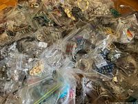 Overview of multiple ziplock bags filled with assorted costume jewelry pieces, various colors and styles visible.