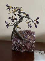 Front view of decorative tree sculpture with amethyst leaves on purple quartz base with lot tag visible.