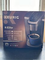 Front and side views of the Keurig K-Elite coffee maker box showing the product image and features.