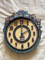 Full clock face showing 3D train running on perimeter track, scenic mountain background and raised numbers on clock face.